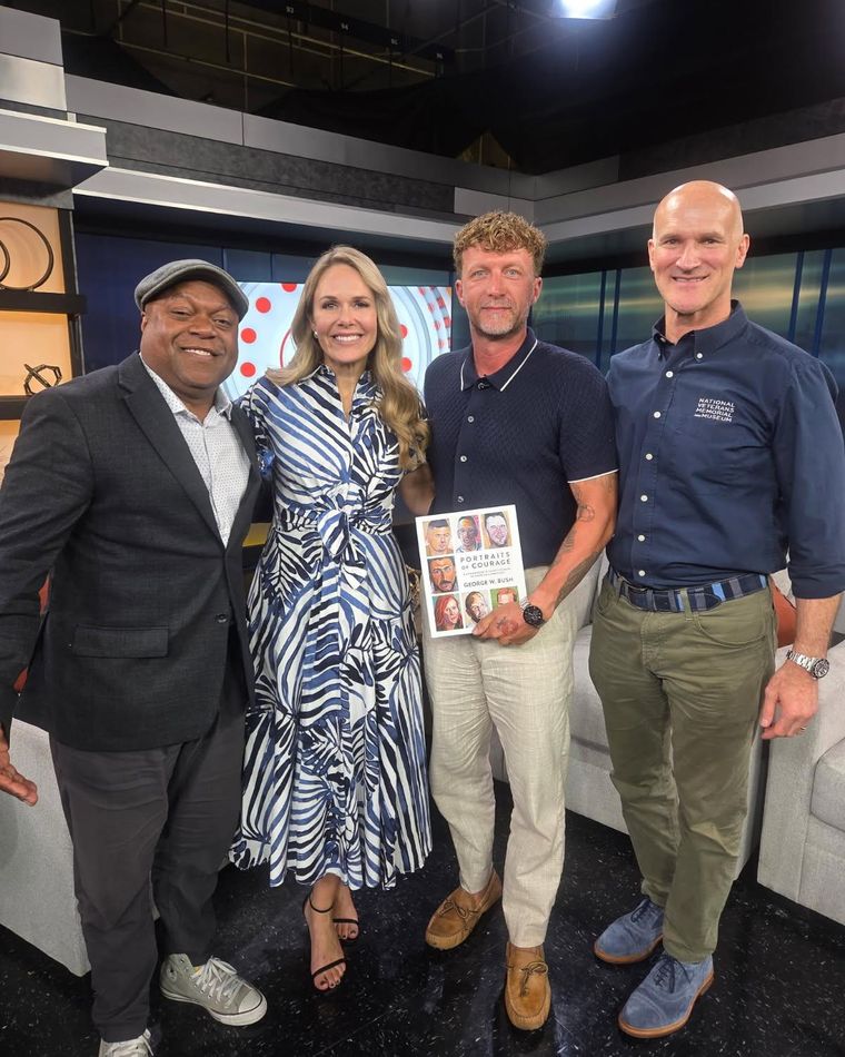Zachariah Collett holding the Portraits of Courage book with fellow guests at a television studio